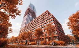 Кирпичный корпус и стеклянная башня ЖК КОД Сокольники — ракурс снизу вверх на фоне неба